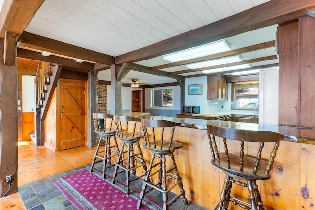 44 Periwinkle Ln, Phippsburg, ME 04562 - kitchen with decorative backsplash, beam ceiling, a kitchen breakfast bar, and a peninsula