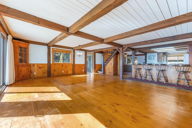 44 Periwinkle Ln, Phippsburg, ME 04562 - unfurnished living room featuring beamed ceiling, wainscoting, an inviting chandelier, and wood-type flooring
