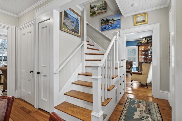 stairway featuring crown molding and hardwood / wood-style flooring