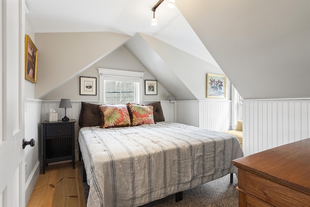 bedroom with lofted ceiling and wood finished floors