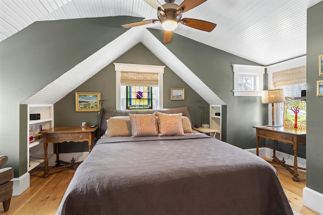 bedroom with a ceiling fan, vaulted ceiling, baseboards, and light wood-type flooring