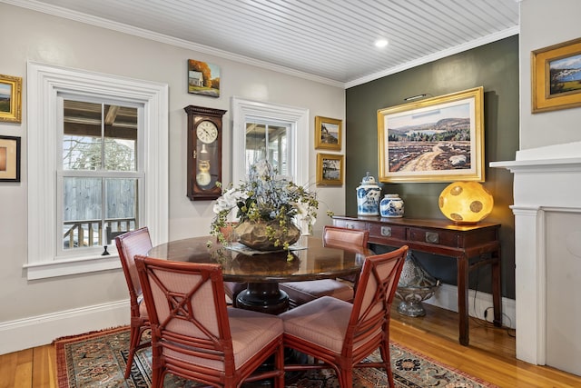 dining room with wood finished floors, baseboards, and ornamental molding