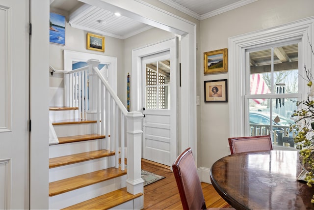 interior space with crown molding, wood finished floors, and baseboards