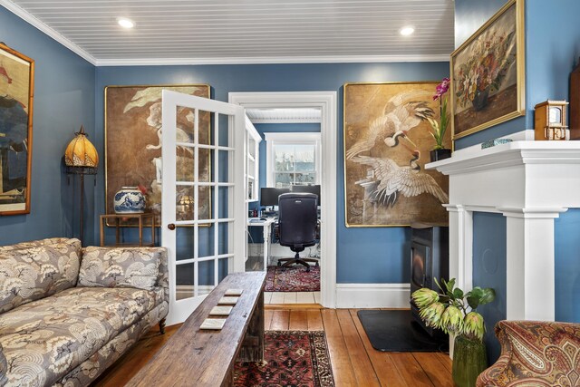 living area with recessed lighting, hardwood / wood-style flooring, baseboards, and ornamental molding