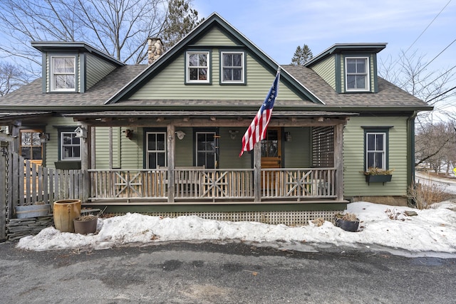 view of front of property featuring covered porch and a shingled roof