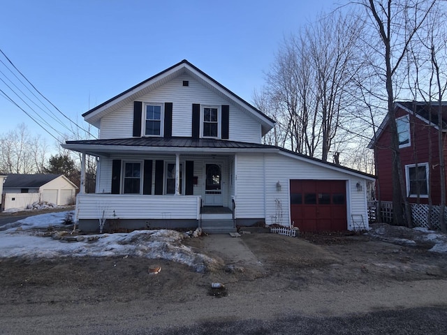 view of front facade with a porch, a garage, and metal roof