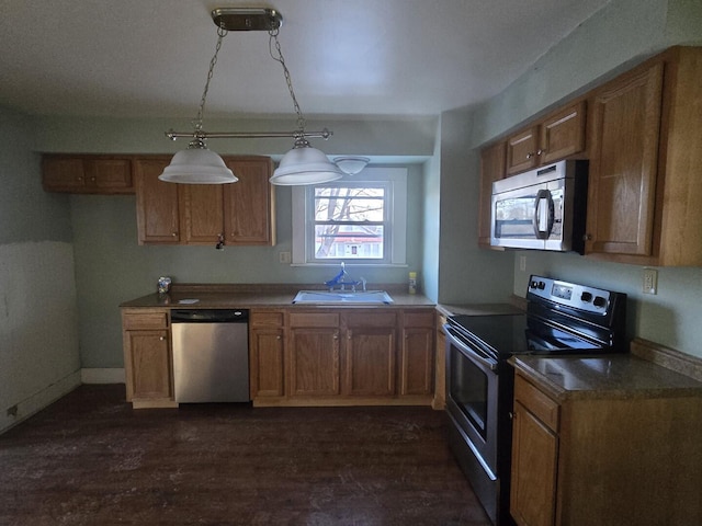 kitchen featuring brown cabinets, appliances with stainless steel finishes, and a sink