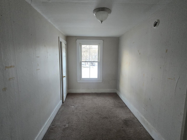 empty room featuring carpet flooring and baseboards