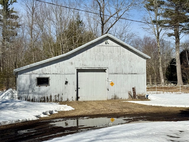 snow covered structure with an outbuilding and an outdoor structure