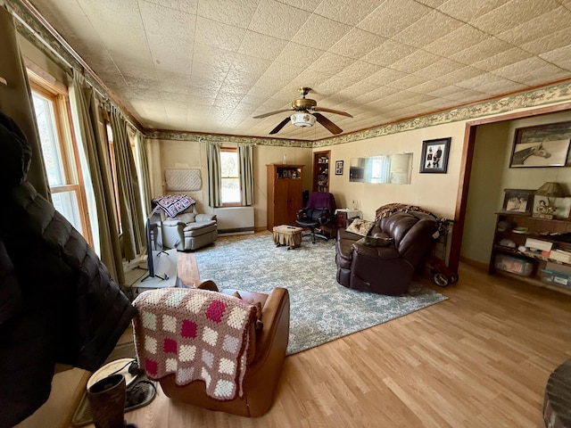 living area with ceiling fan, baseboards, and wood finished floors