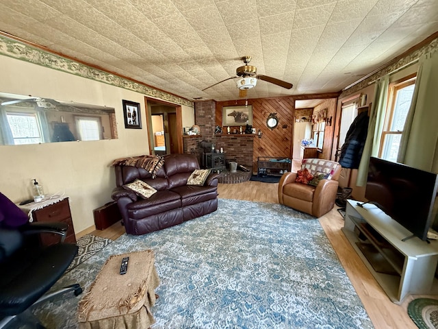 living room featuring wood finished floors, wood walls, and ceiling fan