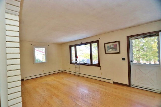 interior space featuring a baseboard heating unit and light wood-style floors