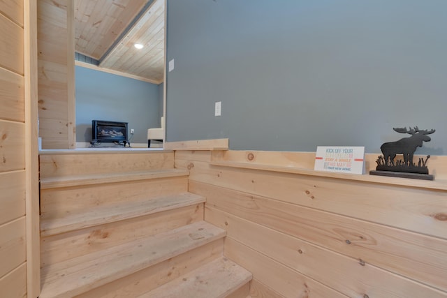 stairway with a wood stove and wood ceiling