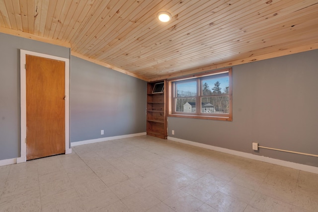 empty room featuring tile patterned floors, wood ceiling, baseboards, and a wall mounted air conditioner