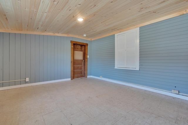 empty room featuring tile patterned floors, baseboards, and wooden ceiling