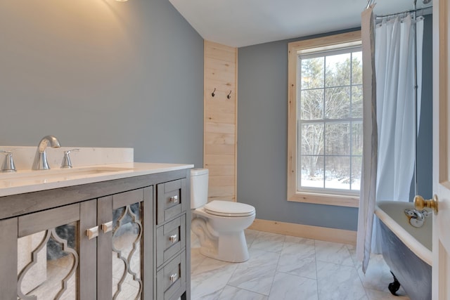 bathroom featuring toilet, marble finish floor, a tub, curtained shower, and baseboards