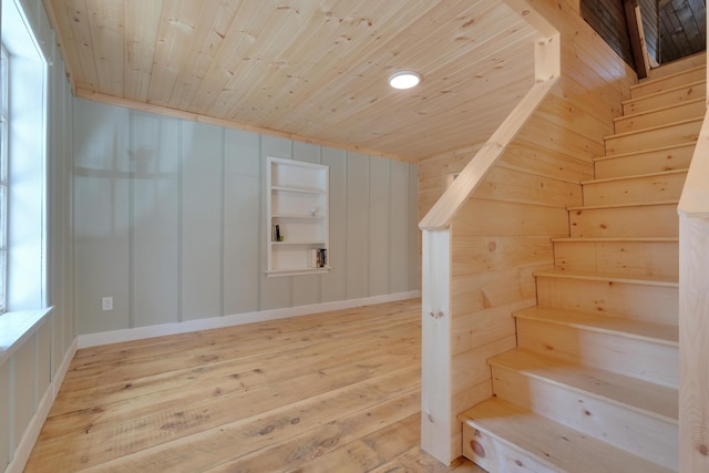 bonus room featuring wooden ceiling, hardwood / wood-style flooring, built in shelves, and stairway