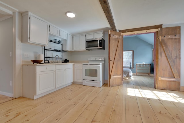 kitchen featuring light wood-style flooring, white electric range, stainless steel microwave, a barn door, and vaulted ceiling with beams