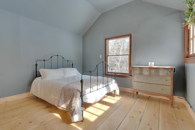 bedroom with hardwood / wood-style flooring and vaulted ceiling