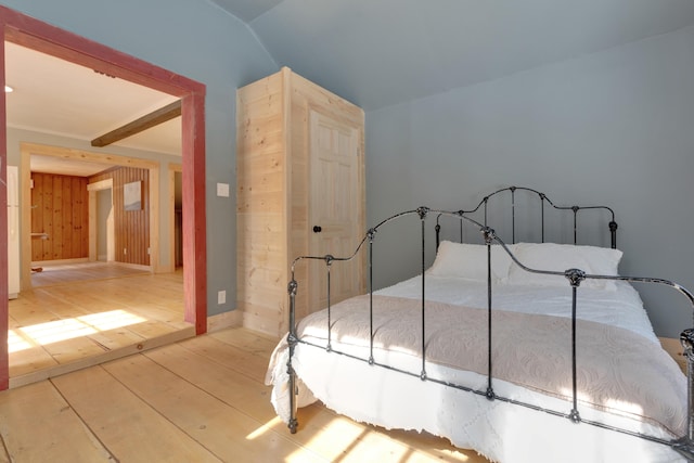 bedroom with vaulted ceiling and wood-type flooring