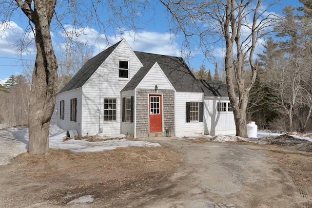 cape cod house with entry steps, aphalt driveway, and roof with shingles