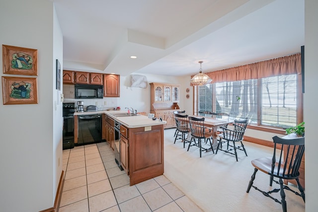 kitchen with a peninsula, light tile patterned flooring, decorative backsplash, black appliances, and brown cabinets