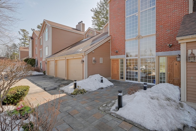 rear view of house featuring a garage and driveway