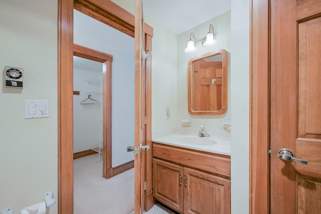 half bathroom with vanity and baseboards