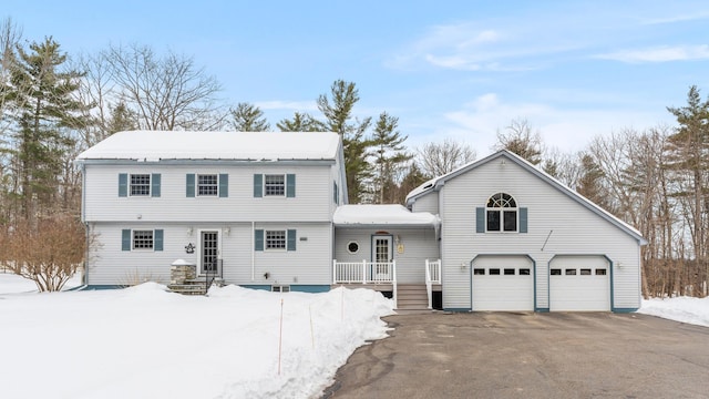 colonial inspired home featuring aphalt driveway and an attached garage