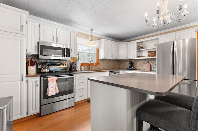 kitchen featuring a breakfast bar, light wood-style flooring, white cabinets, stainless steel appliances, and open shelves