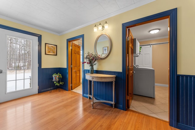 foyer with a barn door, washer / dryer, and wainscoting