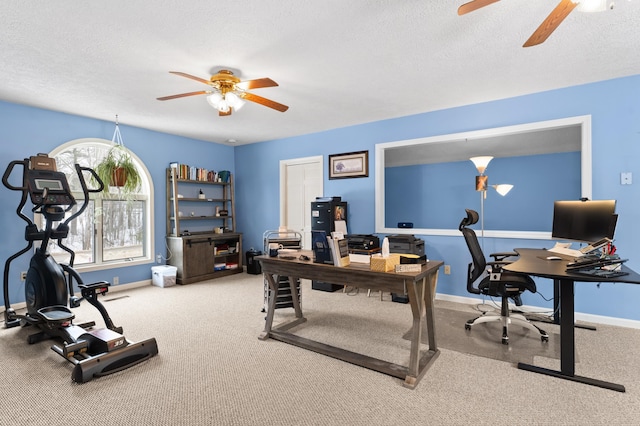 carpeted office featuring baseboards, a textured ceiling, and a ceiling fan