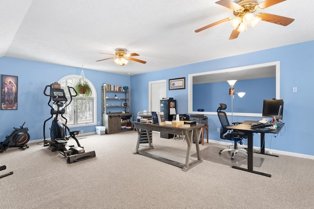 carpeted office space featuring baseboards, a textured ceiling, and ceiling fan