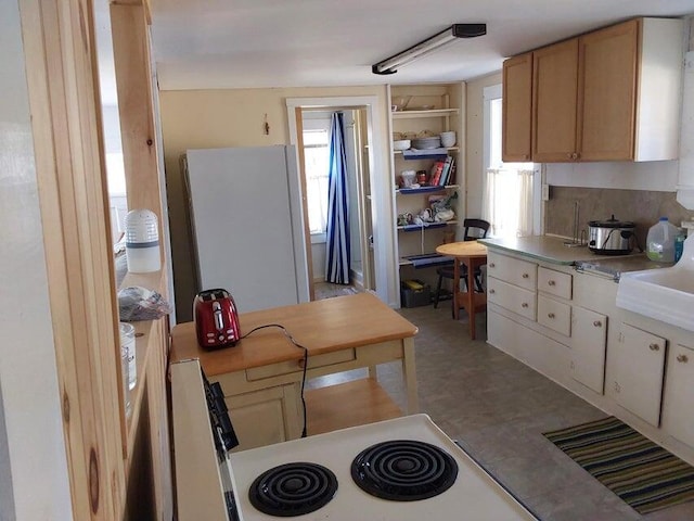 kitchen featuring tile patterned floors, light countertops, electric range oven, and freestanding refrigerator