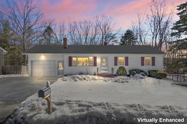 single story home featuring an attached garage, a chimney, driveway, and fence