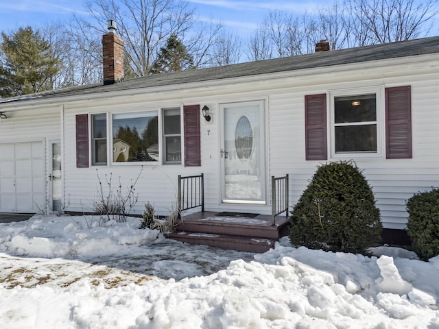 view of front of home featuring an attached garage and a chimney