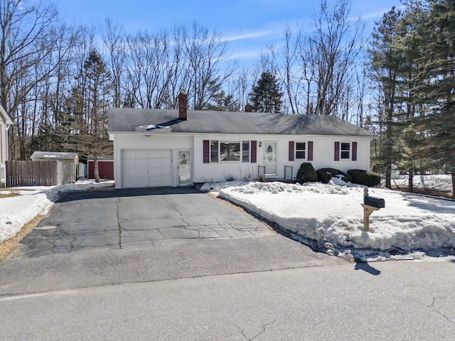 ranch-style home featuring a garage, a chimney, driveway, and fence