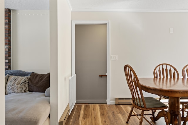 dining room featuring crown molding, wood finished floors, baseboards, and a textured ceiling