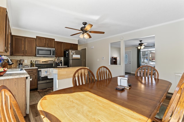 dining area featuring crown molding, ceiling fan, and dark wood-style flooring