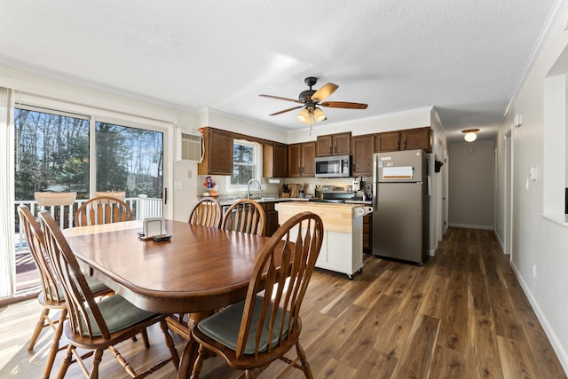 dining area featuring crown molding, baseboards, dark wood-style flooring, and a wall mounted air conditioner