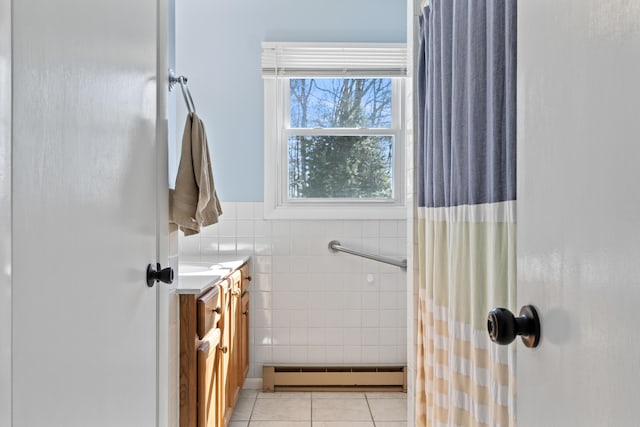 full bathroom featuring tile patterned flooring, vanity, wainscoting, tile walls, and a baseboard radiator