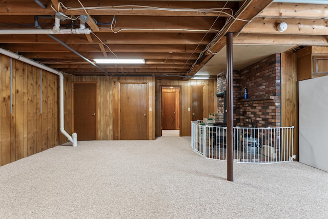 unfinished basement with carpet flooring and wood walls