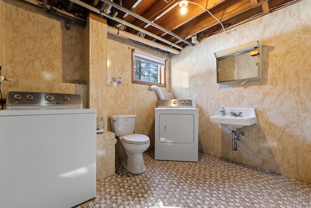 washroom featuring washing machine and clothes dryer, laundry area, and a sink