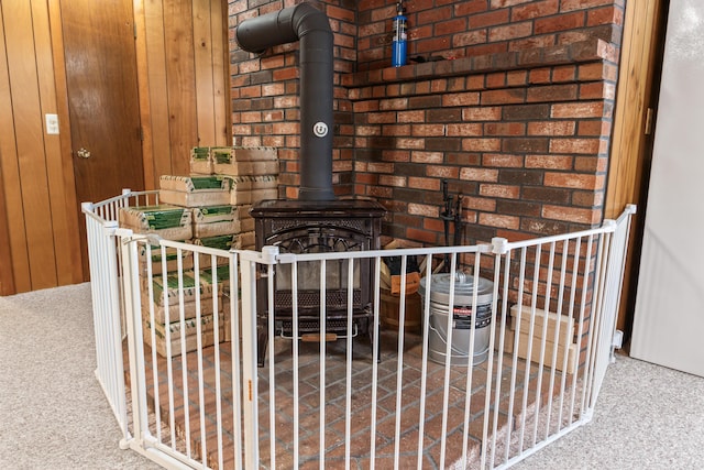 interior details featuring wood walls, a wood stove, and carpet floors