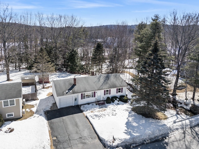 snowy aerial view featuring a wooded view