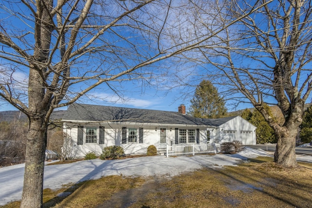 view of front of property with a garage, a chimney, a porch, and driveway