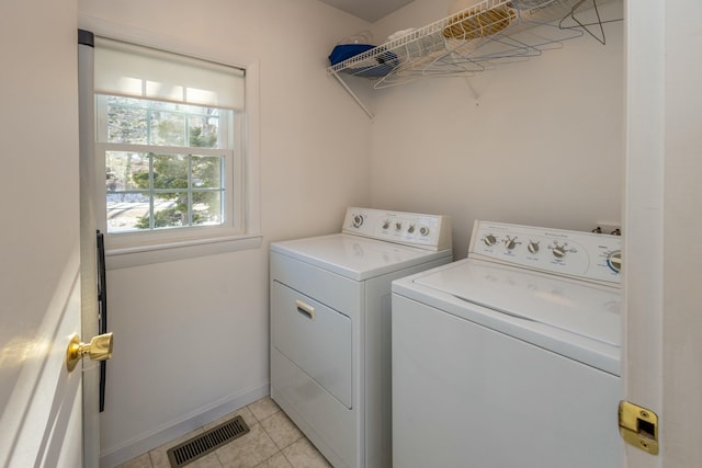 laundry area with visible vents, baseboards, washing machine and dryer, light tile patterned floors, and laundry area