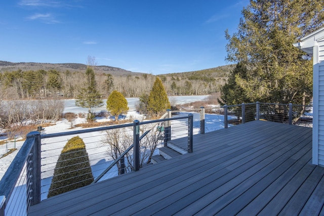 wooden deck featuring a forest view and a mountain view