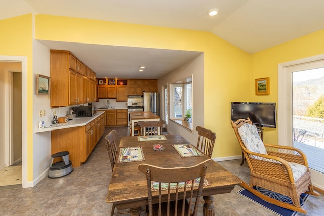 dining space featuring vaulted ceiling and baseboards