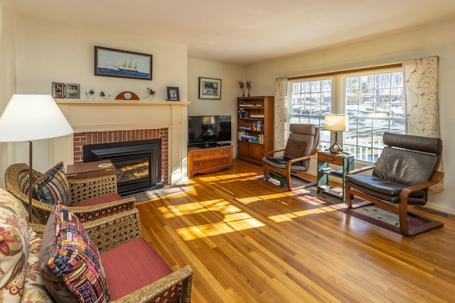 living room with a fireplace and wood finished floors